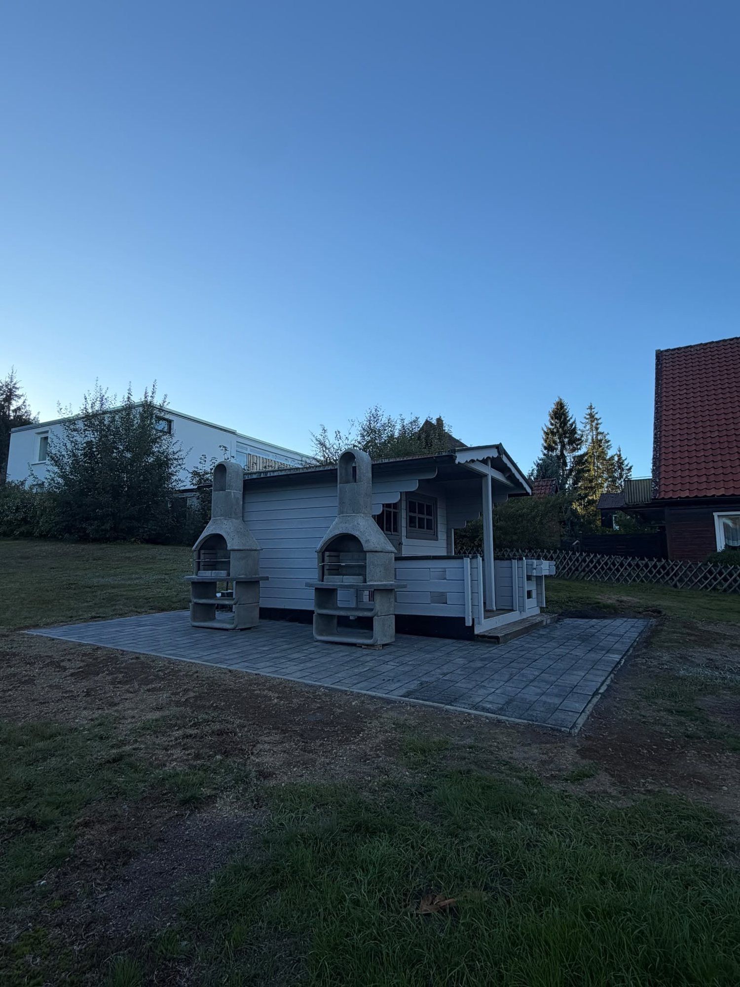Gartenhaus mit zwei Grillkaminen auf neu gepflasterter Fläche